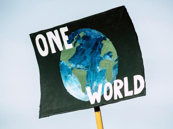 A sign with a globe that says one world