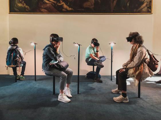Quatre personnes assises dans une pièce et portant des casques de RV