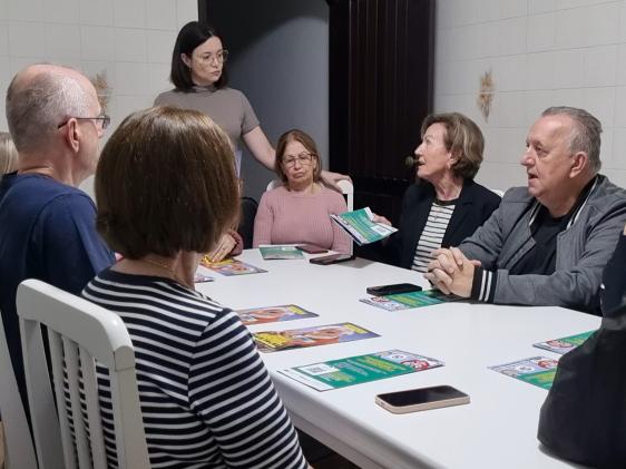 Talita standing at a table full of workshop attendees.