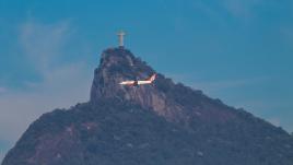 Avião voando com a estátua do Cristo Redentor no pano de fundo no Rio de Janeiro