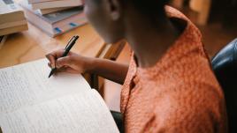 Photo of woman writing on notebook