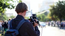 An image of the back of a person who is shooting video