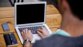 man typing on laptop