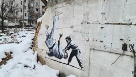 Рисунок Бэнкси - мальчик бросает на пол каратиста - на стене разрушенного дома в Бородянке, Украина