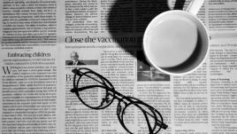 cup of coffee and eyeglasses on a newspaper