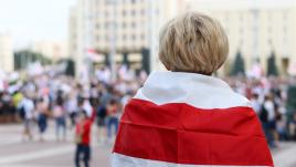 Child with Belarus opposition flag draped around shoulders