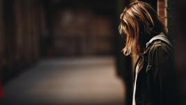 Woman in profile looking down on a street