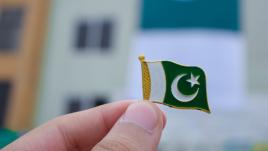 Person holding up a pin of flag of Pakistan