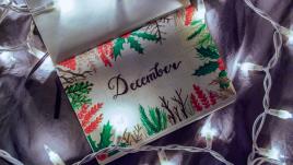 A calenndar with December on it surrounded by a string of lights.