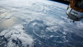 Vue de la Terre depuis l'espace, avec un satellite dans un coin