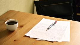 Pen and coffee on desk with papers 