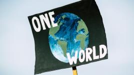 Un cartel con un globo terráqueo que dice "un mundo"