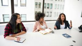 Three women at a table  in a well-lit office