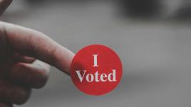 Calcomanía que dice "Yo voté" en letras blancas sobre fondo rojo
