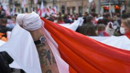 A man holding the national flag of Belarus, the march on Freedom Day of Belarus 2023 in Warsaw