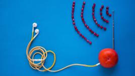 Artistic depiction of a podcast, with headphones plugged into an orange and radio waves made of beans