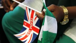 Homme tenant un drapeau britannique et un drapeau nigérian