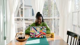 Woman in front of a colorful computer in a well lit kitchen