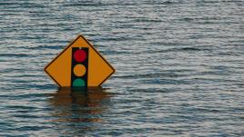 Traffic light sign half submerged in water during a flood