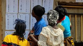 Quatre femmes au Nigéria lisant une liste électorale sur un mur