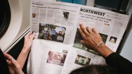 Two people reading a newspaper