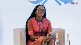 Jennifer Ambolley sur un canapé et tenant un micro