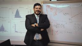 Eleraqi posing in front of a white board.