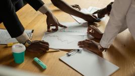 Colleagues pointing to documents and graphs.