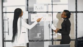 To women reviewing data and charts.