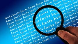 The word facts typed over and over again and a magnifying glass on top.