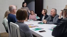 Talita Talita standing at a table full of workshop attendees.